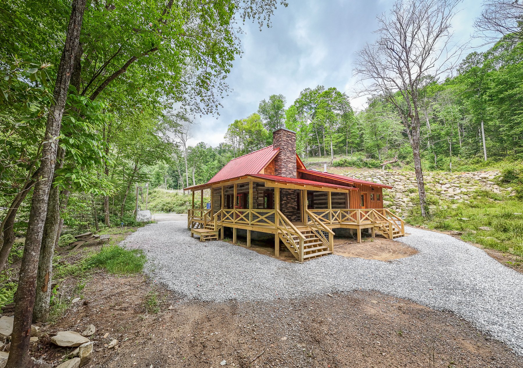 finished cabin from corner with 2 porches and red roof