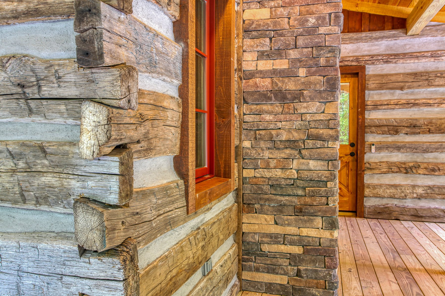 cabin exterior close up with logs fireplace window and door