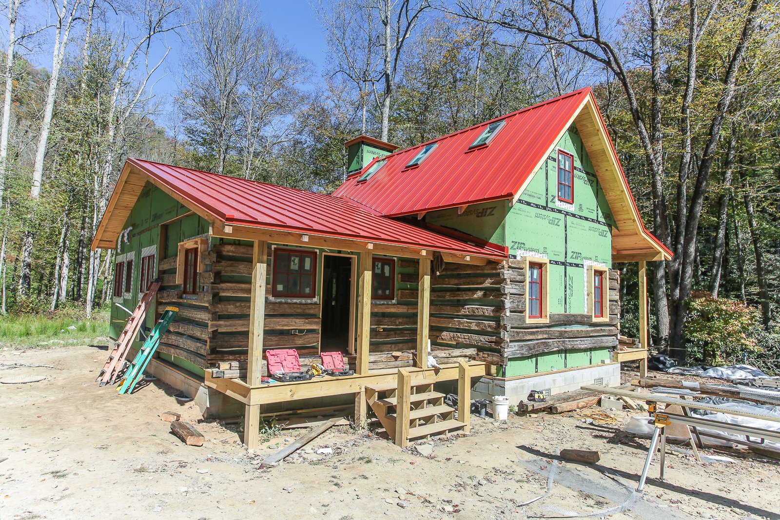 log siding partially complete over zip board on exterior of cabin build